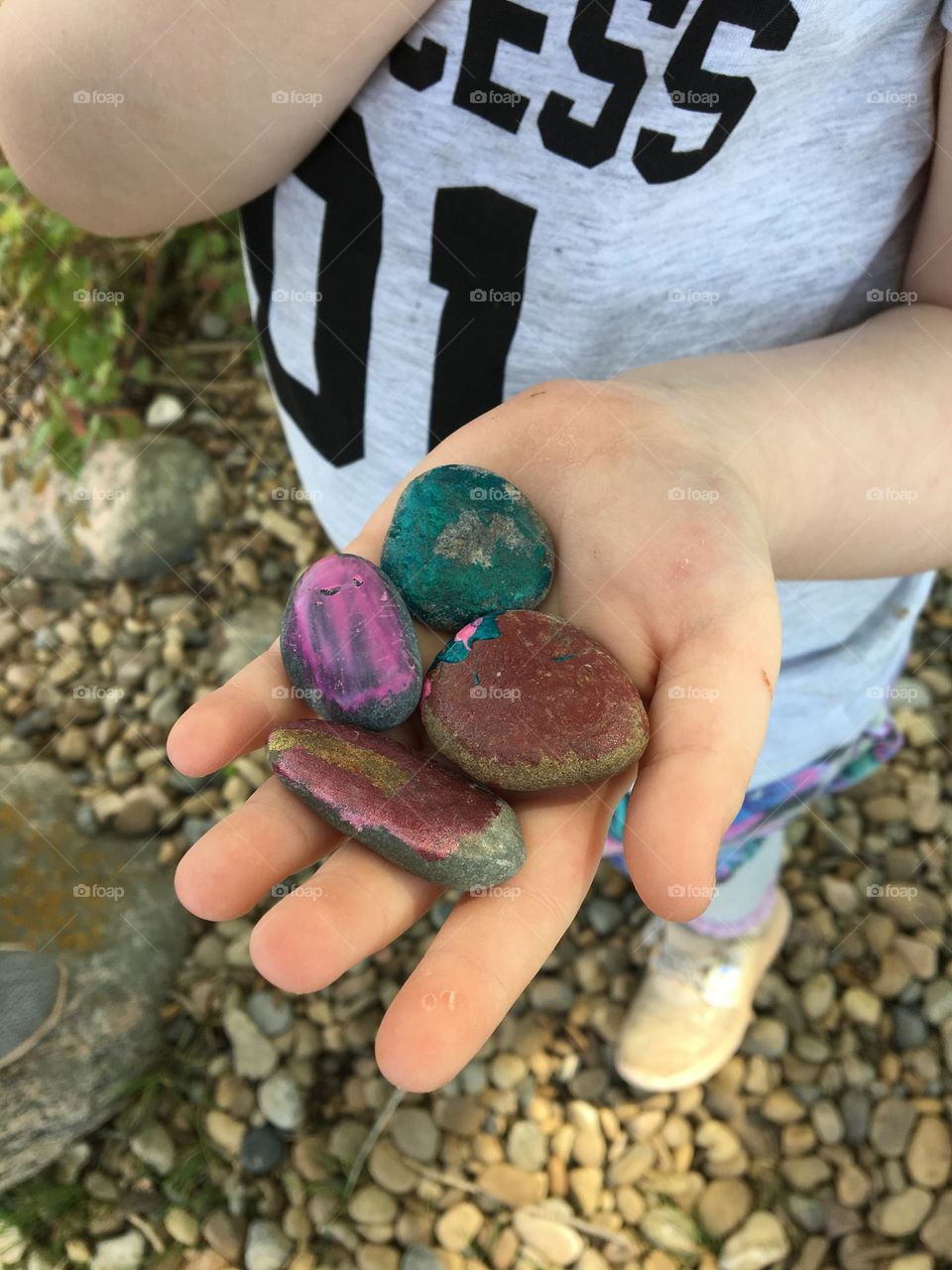 Youth girls hand holding some painted rocks we found at the beach