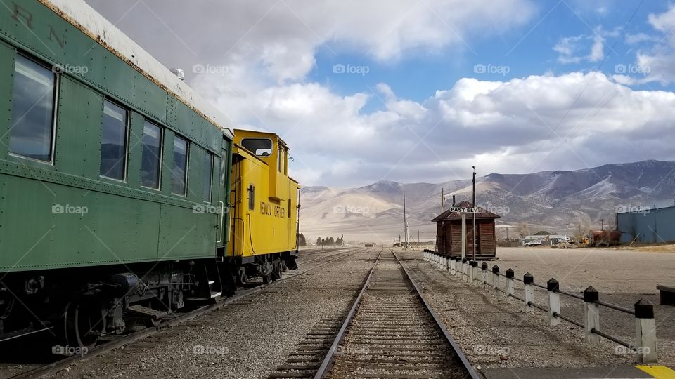 Vintage green and yellow train on tracks in Nevada on a cloudy day