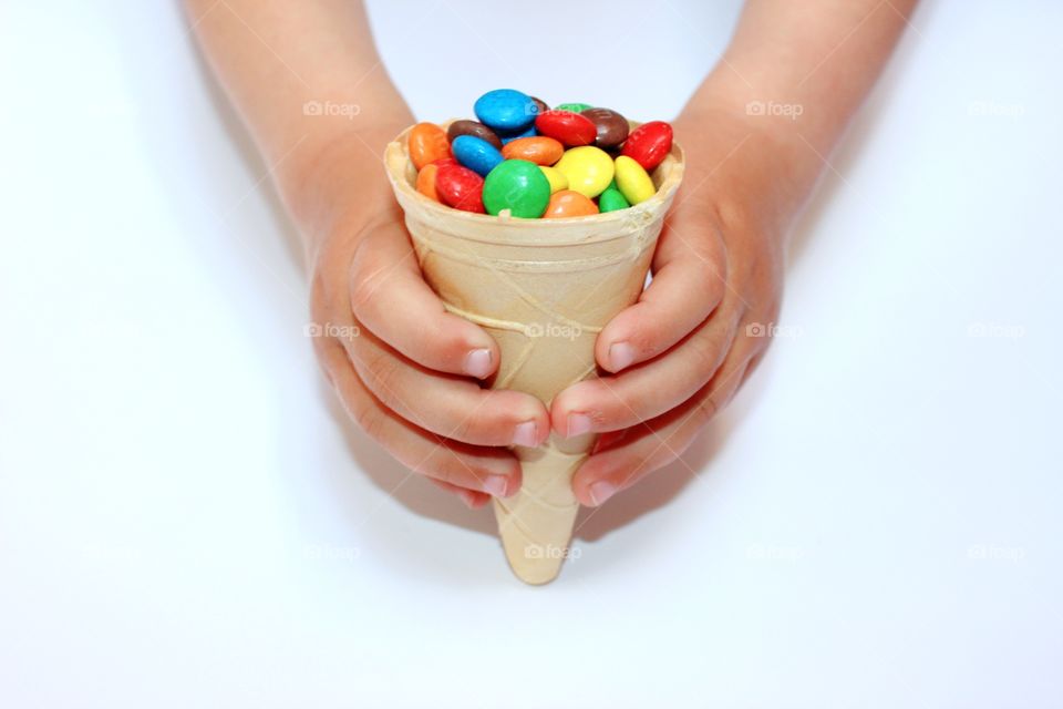 waffle cone with colored dragee in hands