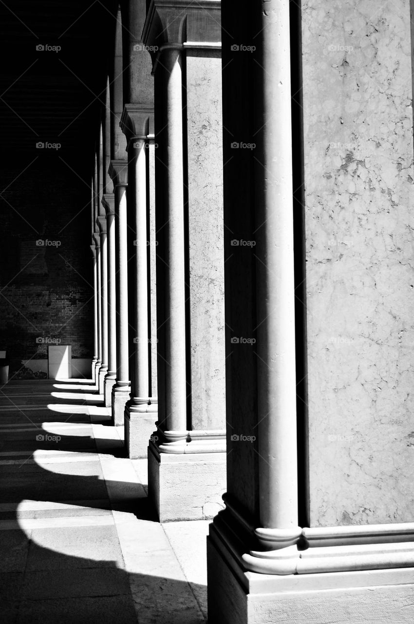Arches of a portico with sunlight filtering through, Venetian palace, Italy 