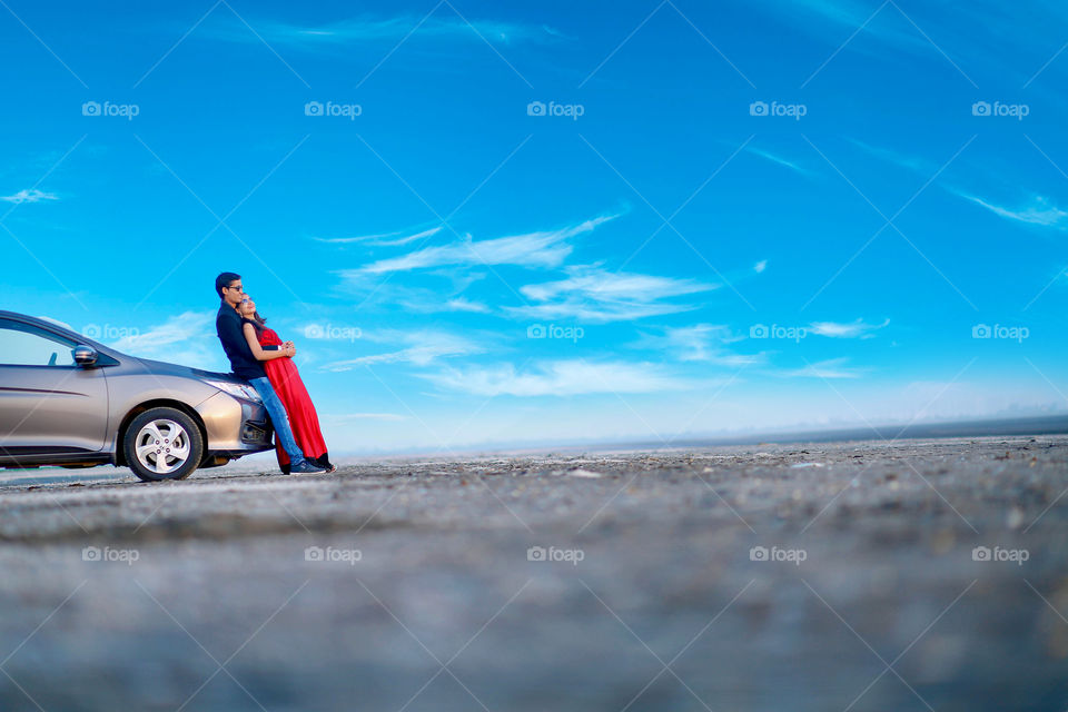 Happy beautiful young couple standing near the car