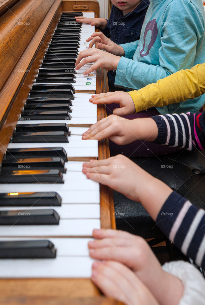 Children learning piano at home.