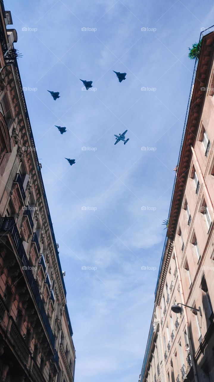 Military aircraft formations during France's National Day celebration.