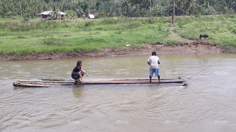 Crossing the river in a bamboo raft. This is in one of the remote areas in the Philippines.
