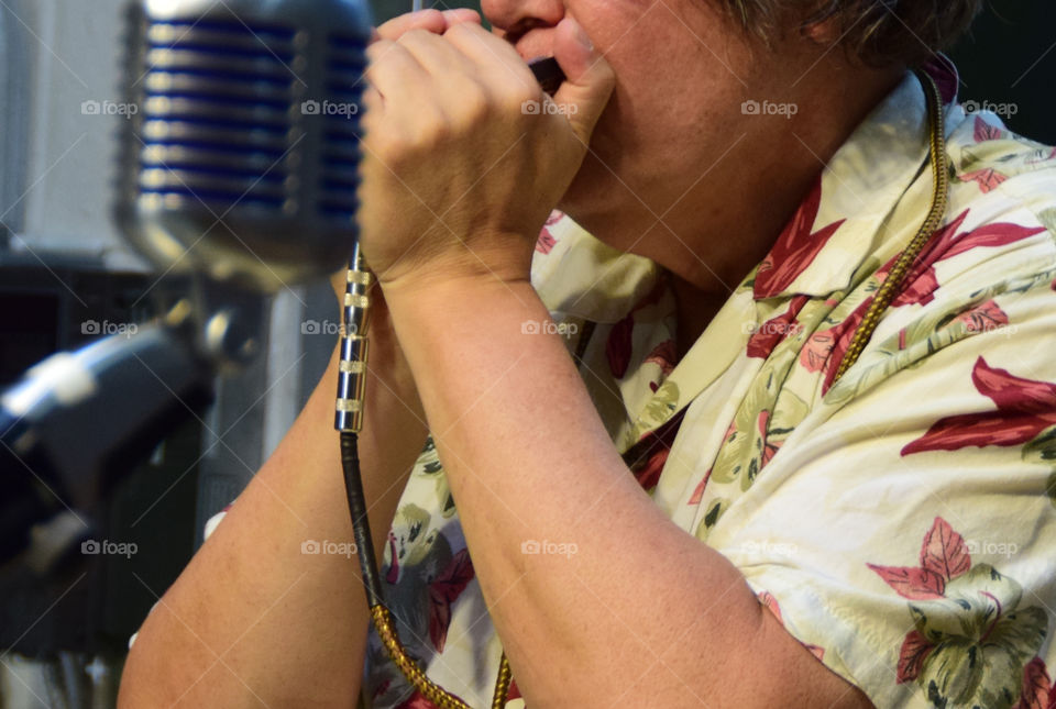 Working hands playing harmonica