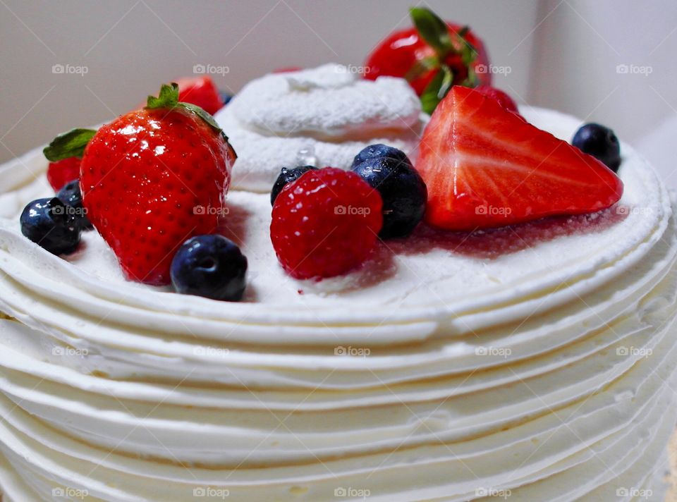 Strawberry and blueberry cake with white frosting 