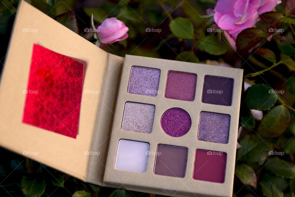 Eye shadow palette on floral background.