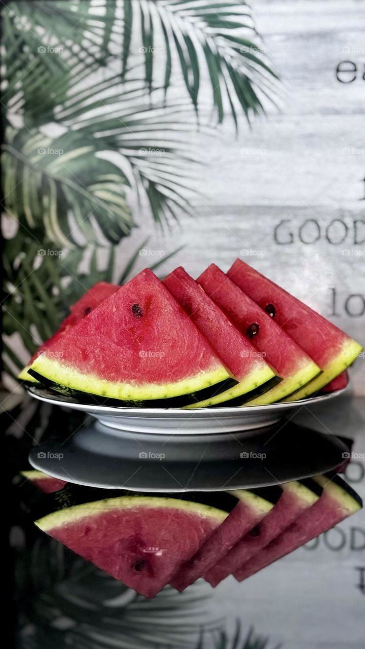 Watermelon slices on a plate, reflection