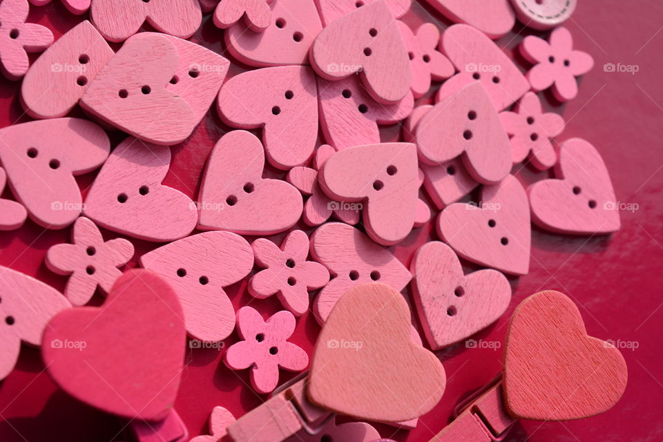 pink color wooden buttons and wood hearts  pink background
