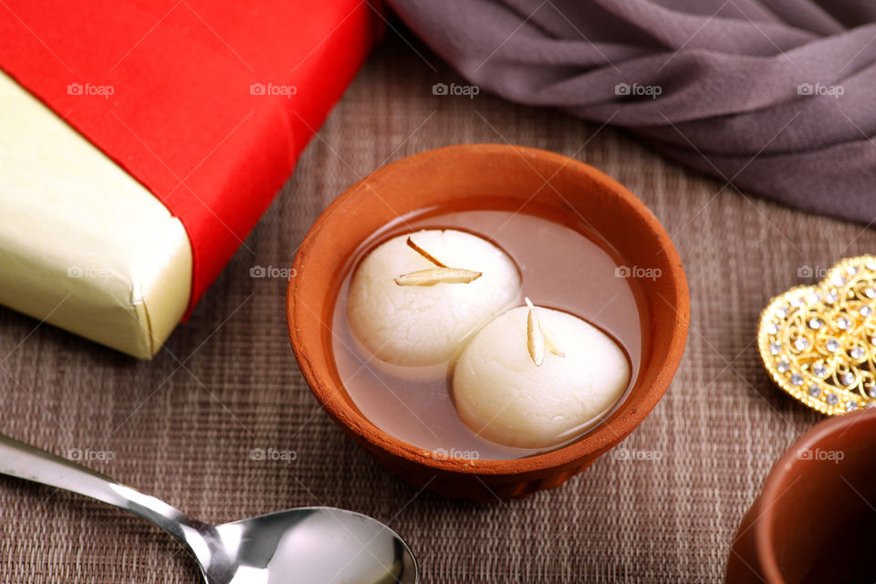 Indian sweet dessert rasgulla with sugar syrup