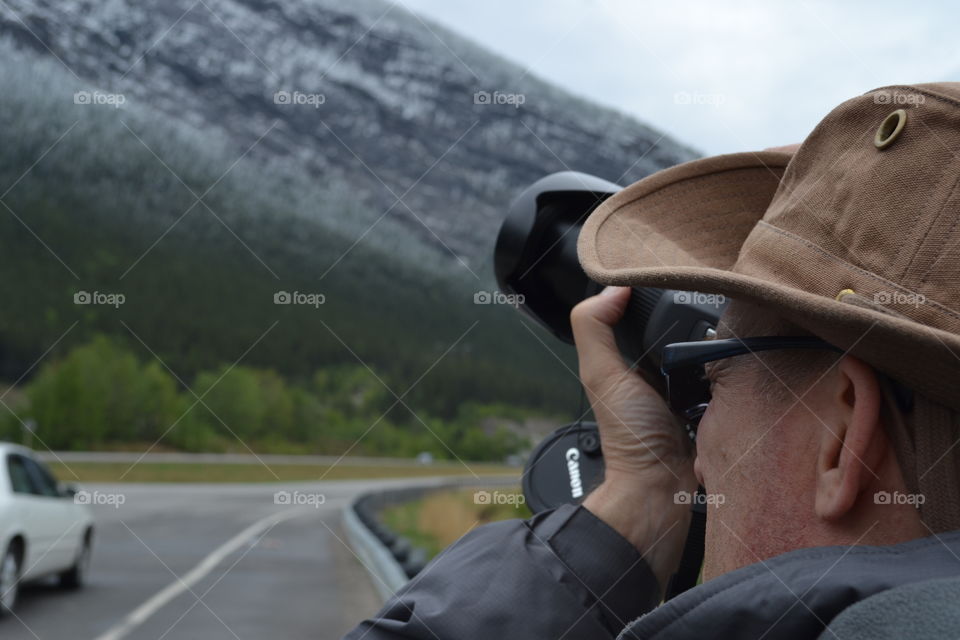 Young photographer photographing in mountain valley