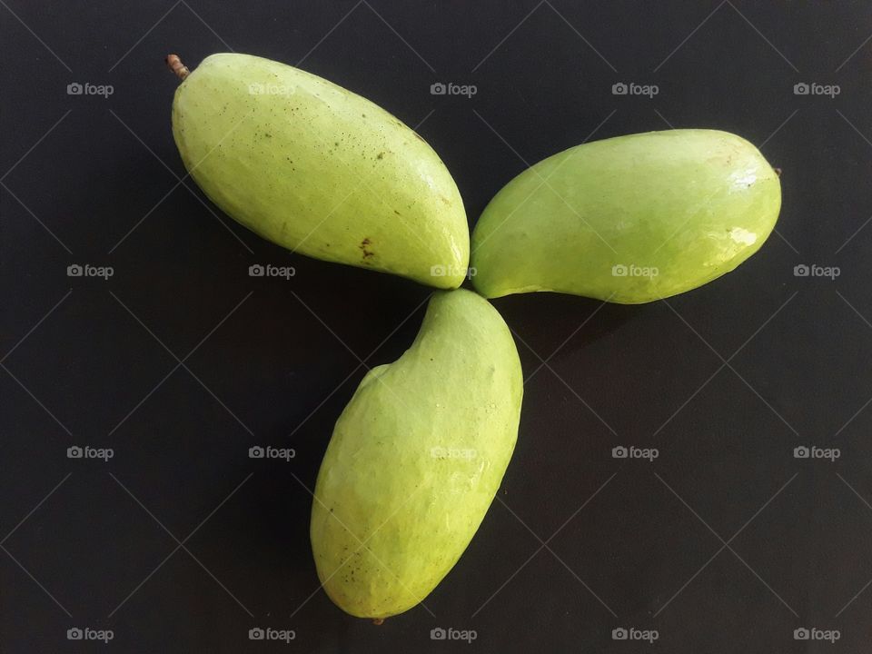 green mangoes on black background
