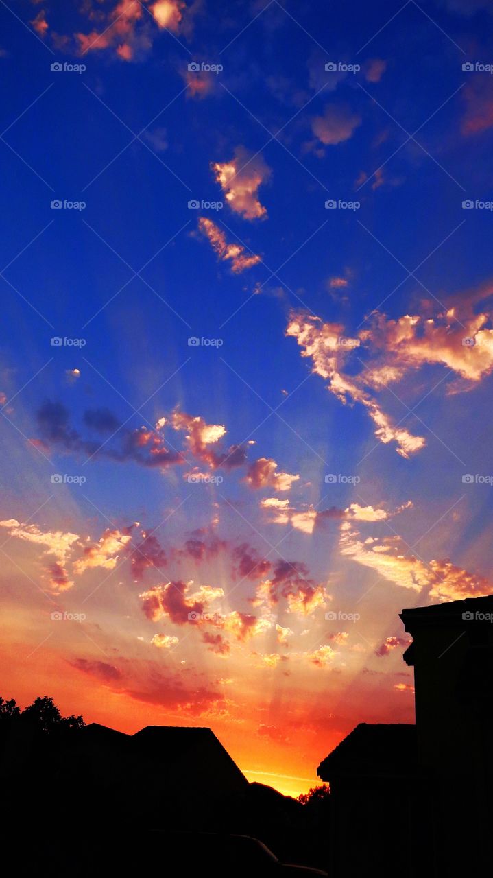 Sunset beauty . Beautiful sunset over our home, sun, clouds housetops, sun rays, 
