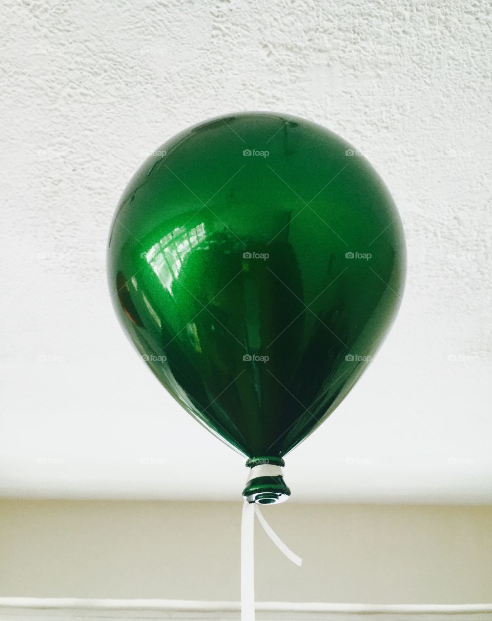 Green balloon tied to a string