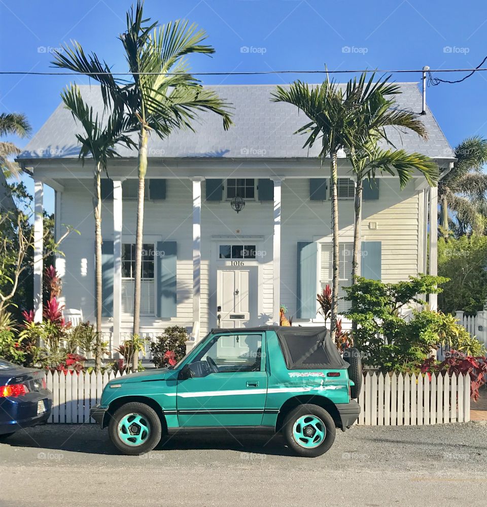 Key West vacation home with turquoise car parked in front. 