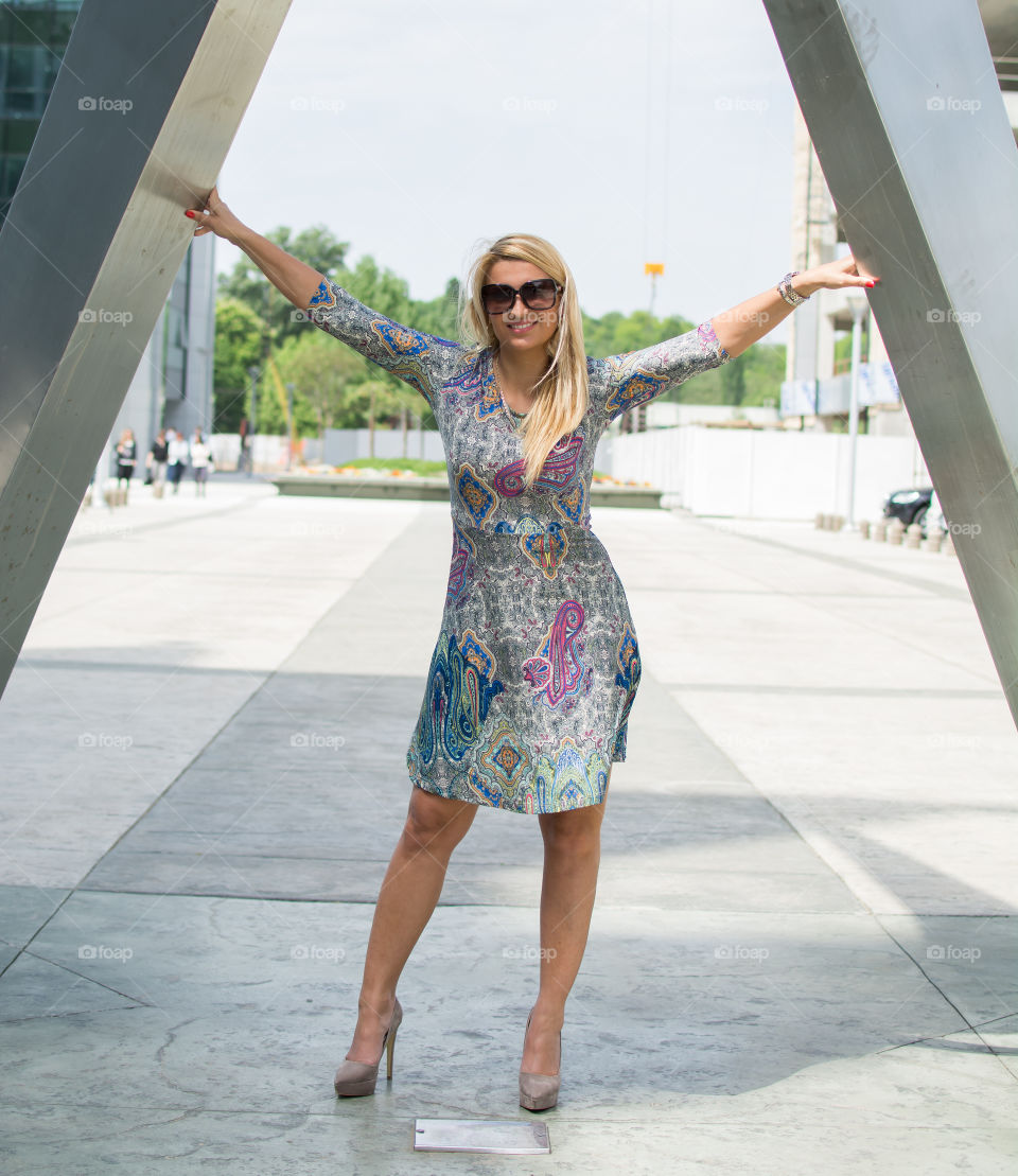 Happy woman standing with sunglasses