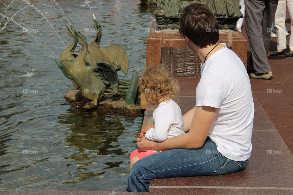 папа с дочкой фонтан в парке