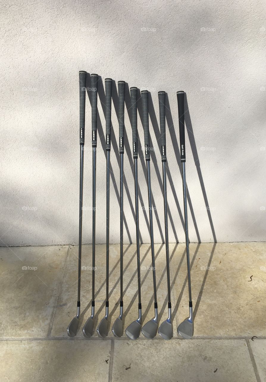Golf clubs along wall 