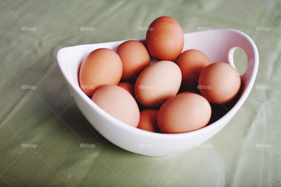 Organic brown eggs in white bowl 