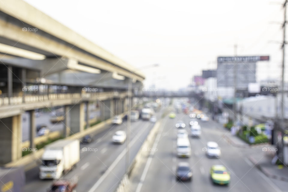 Blurry car driving on the road and sky train stations.