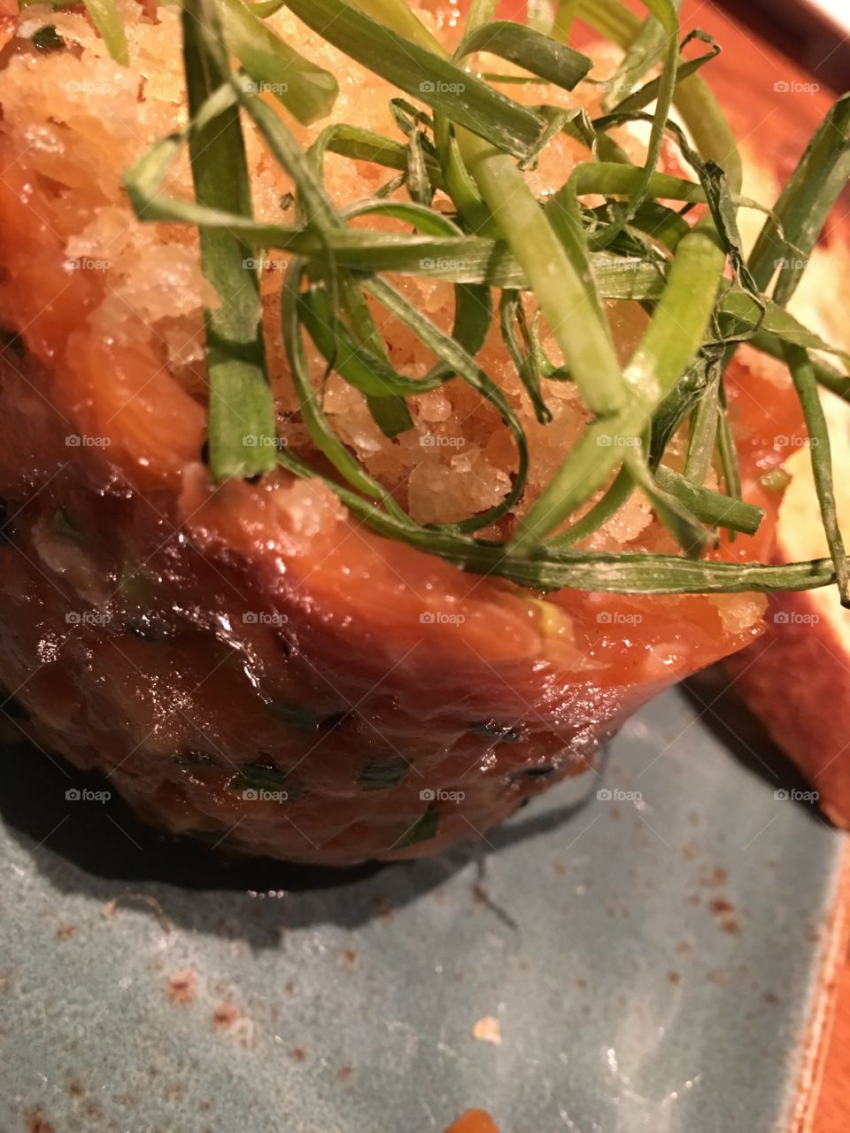 Salmon tartare closeup with dried green onion 