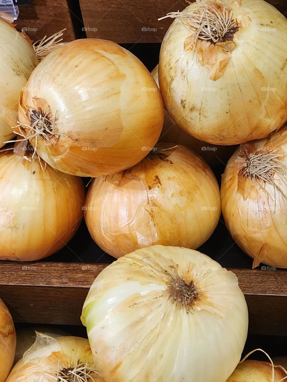 close up view of white onions for sale on a wooden shelf in an Oregon market