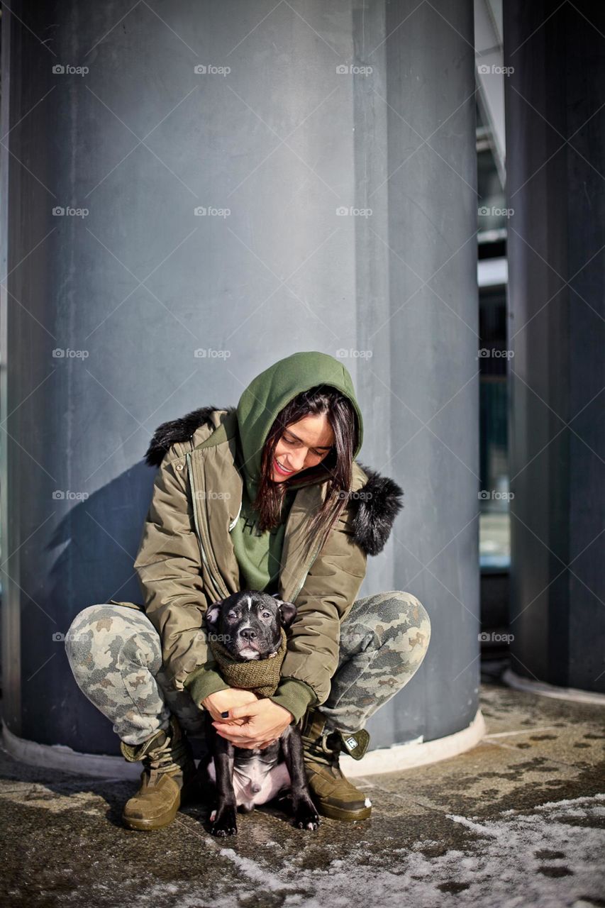 walking the dog down the street, the owner walks the weakling, teaches her, cleans up after her, educates, plays with his pet. people and dogs are best friends