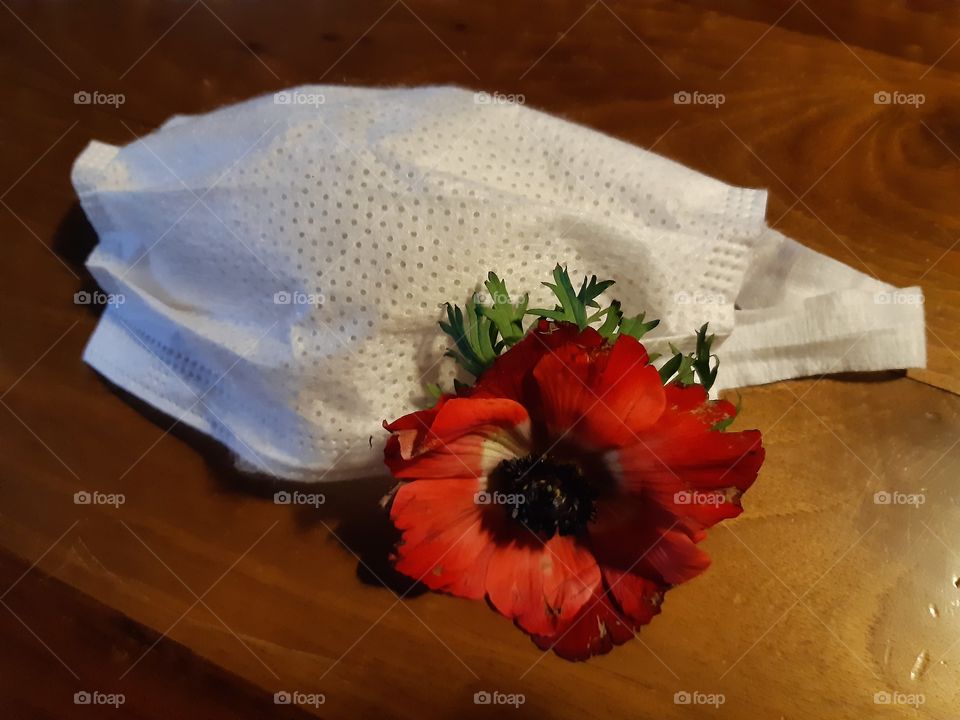white mask with a red flower on the table in the kitchen