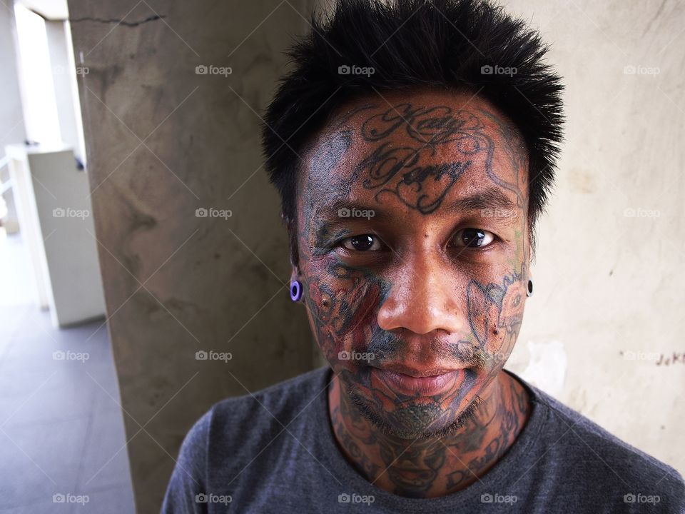 portrait of a man with facial tattoo