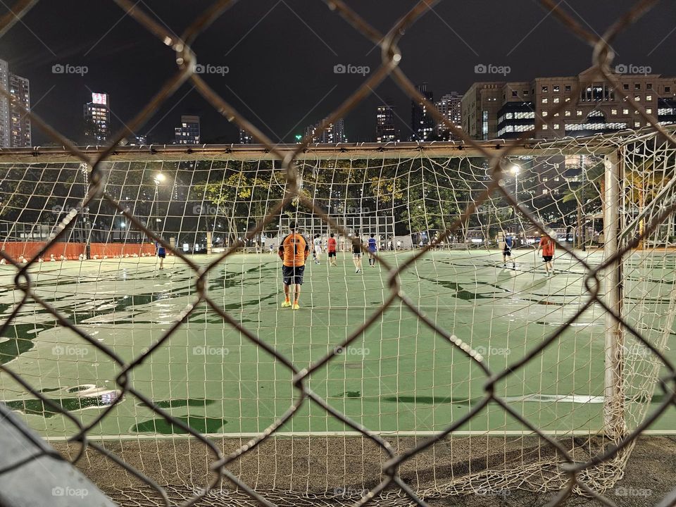 Men playing soccer after the rain at Hong Kong Victoria Park