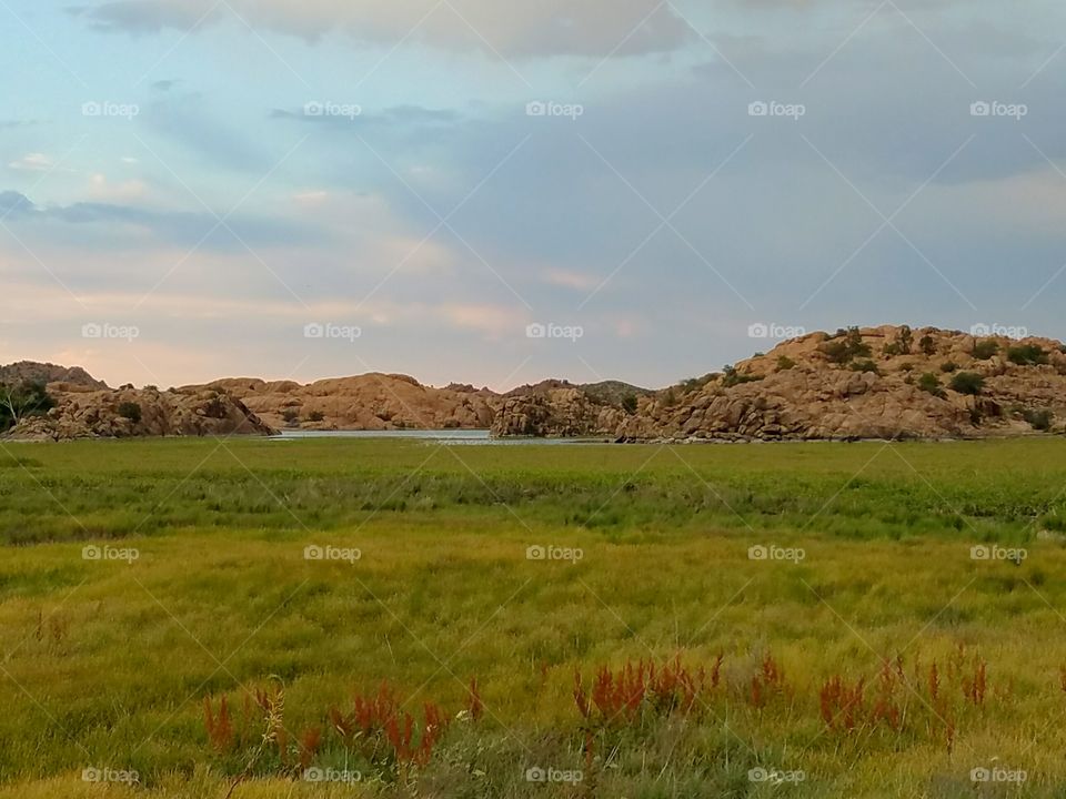 Granite Dells across a field at sunset