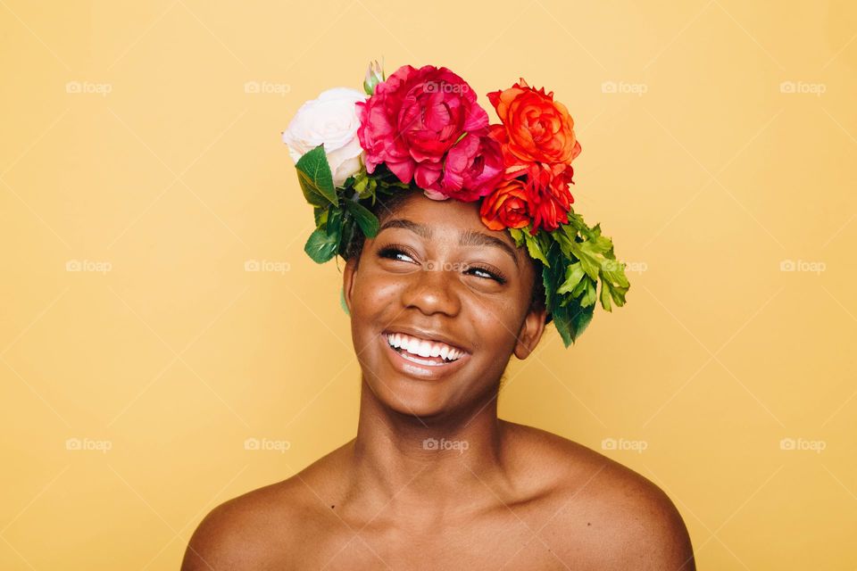 a girl smiling with rose on her Head
