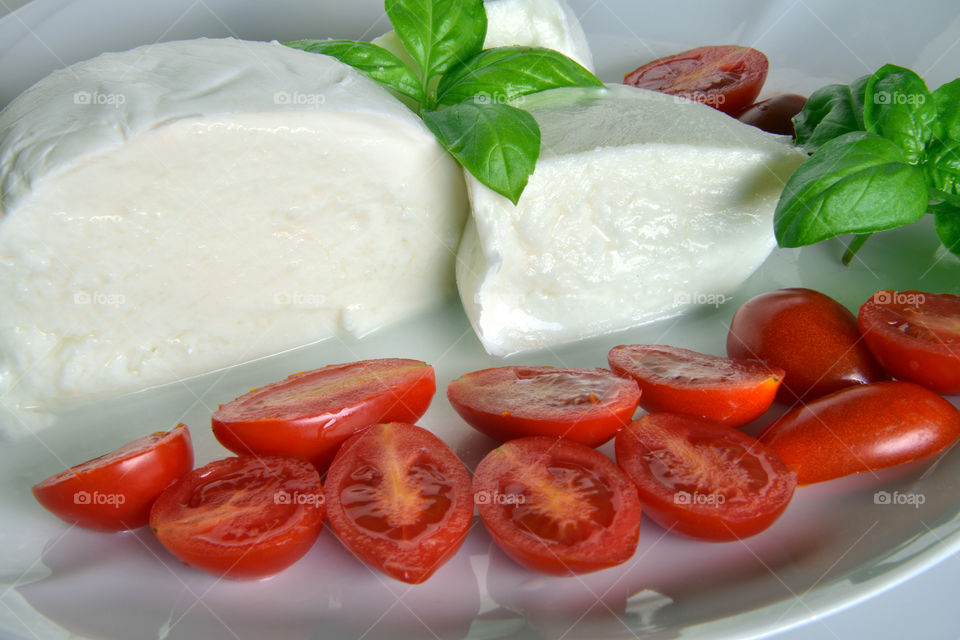 Slice tomatoes with cheese and basil leaf