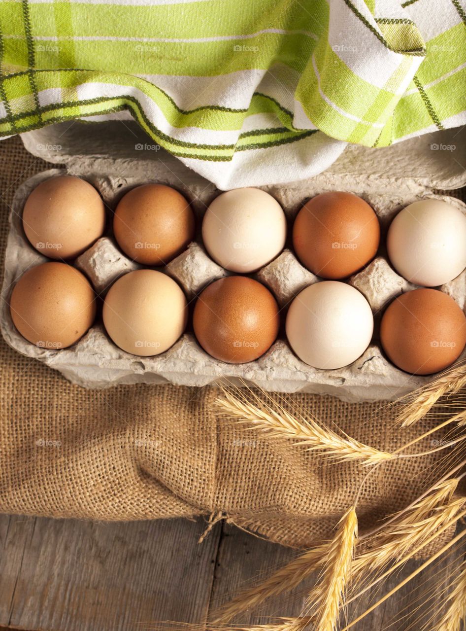Fresh farm eggs on wooden and jute background