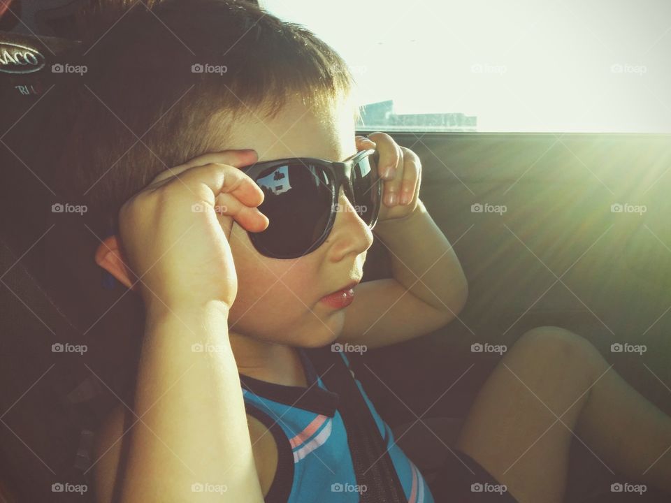 Boy with sunglasses. Boy with sunglasses into car