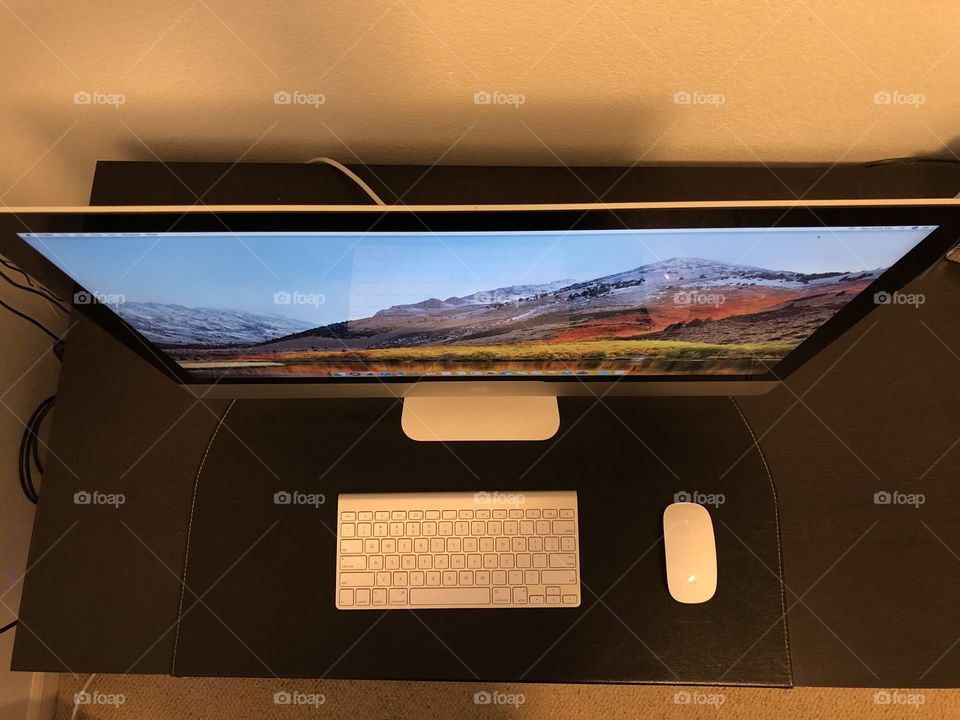 Apple iMac 27” on black desk from above 