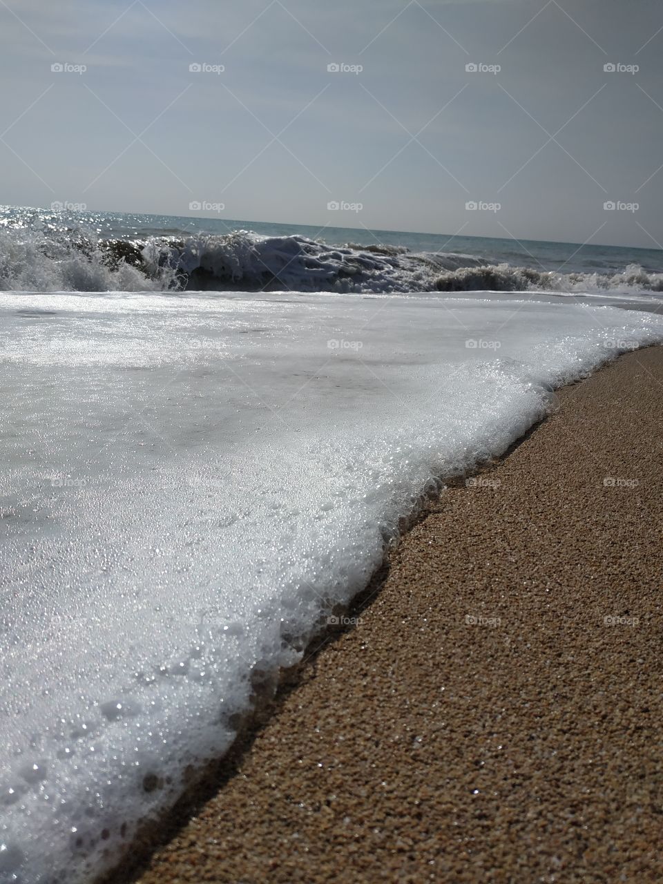 Espuma sobre piedra fina, fotografía tomada en la playa de Peñiscola. La espuma de vuelta al mar me llamó la atención.
