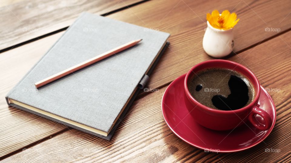 red cup coffee with notebook on the table