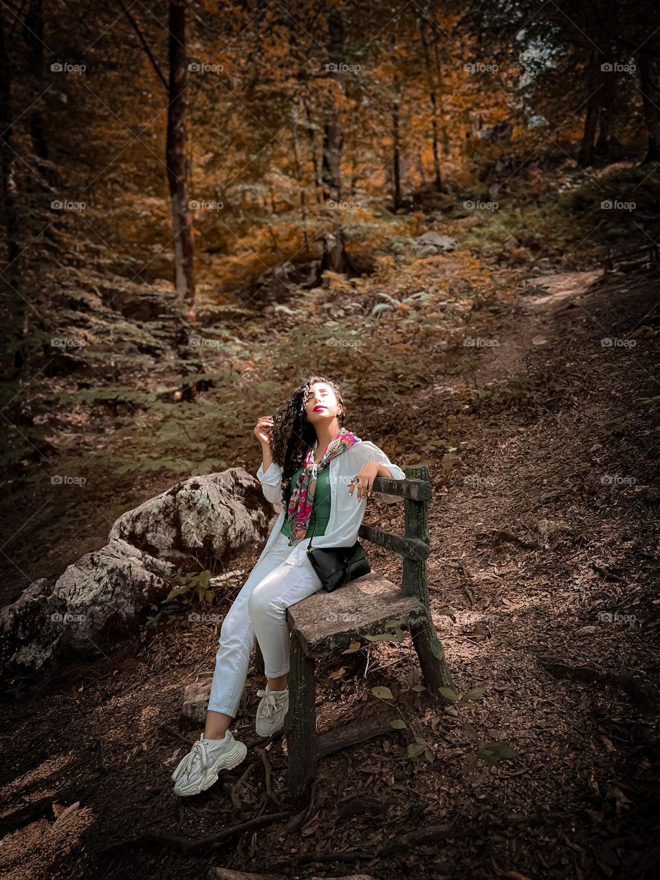 Curly-haired girl in the autumn forest