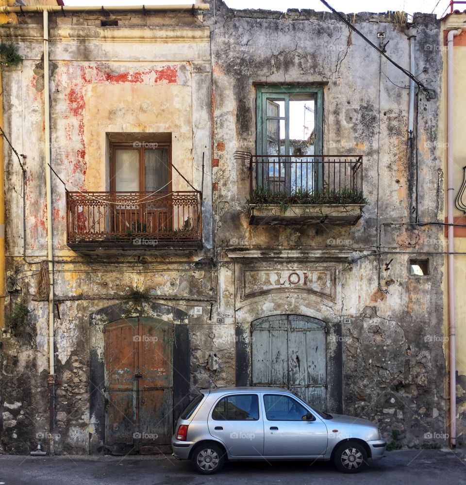 Car parked in front of old buildings in Angri, a small town between Naples and Salerno in the Campania region of southern Italy