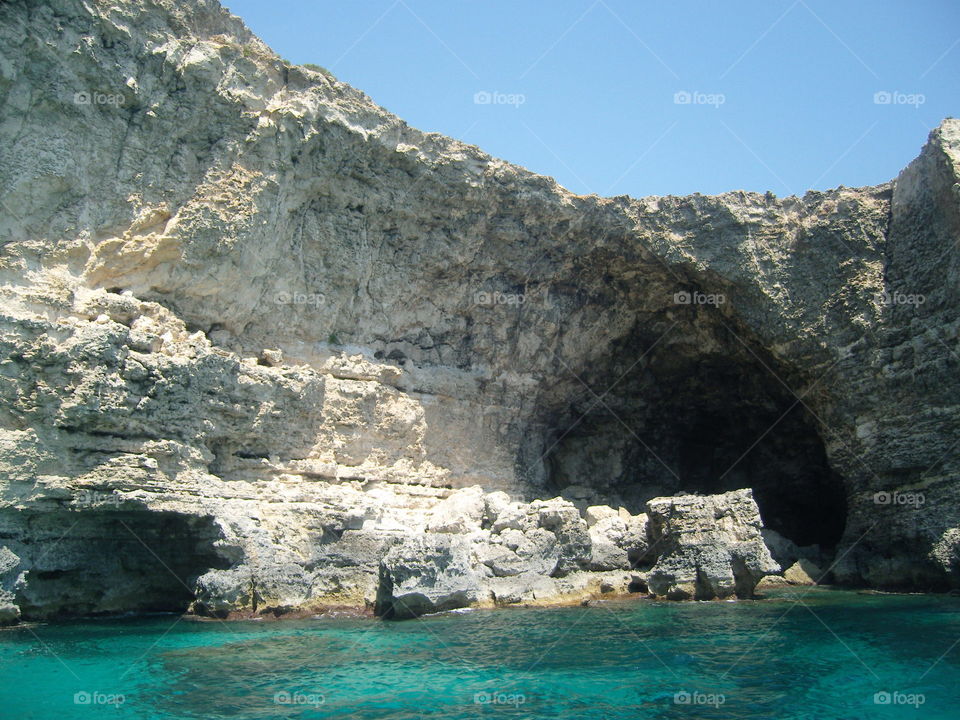 Malta steep limestone slopes on seashore with caves
