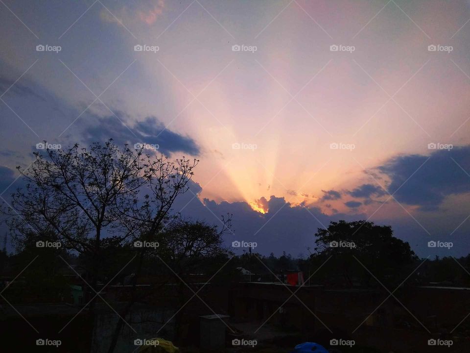 evening time the sun hide withe clouds then the rays come out in clouds