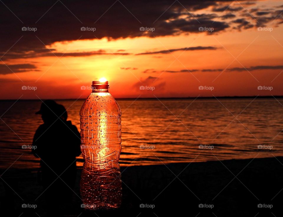 A magnificent Sunset through a discarded plastic water bottle that was collected from the bay