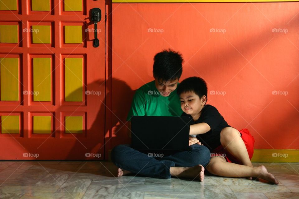 young asian children with a laptop computer in a living room