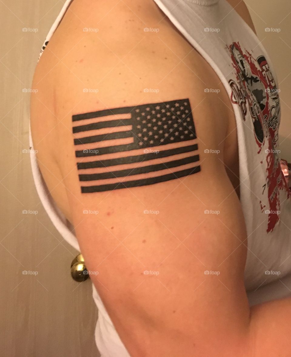 Deployment flag on a bicep, placed exactly where it sits on a U.S. Army uniform. An American soldier. 