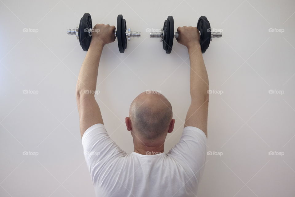 Man raises weights in the gym