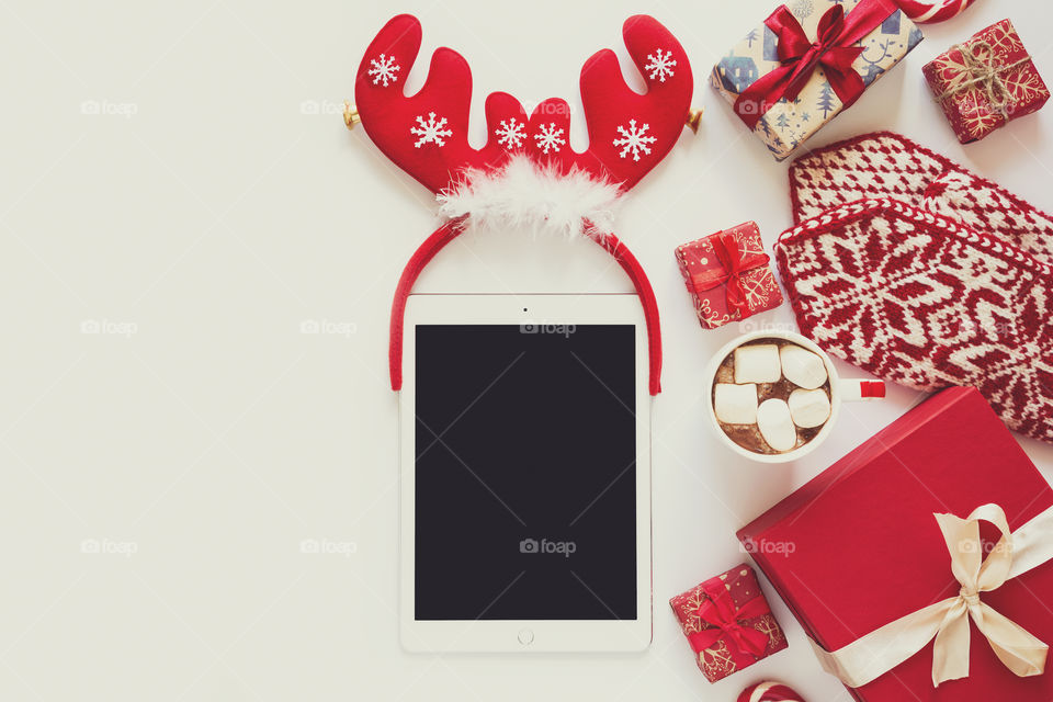 Christmas decorations, tablet, hot chocolate, present box, top view