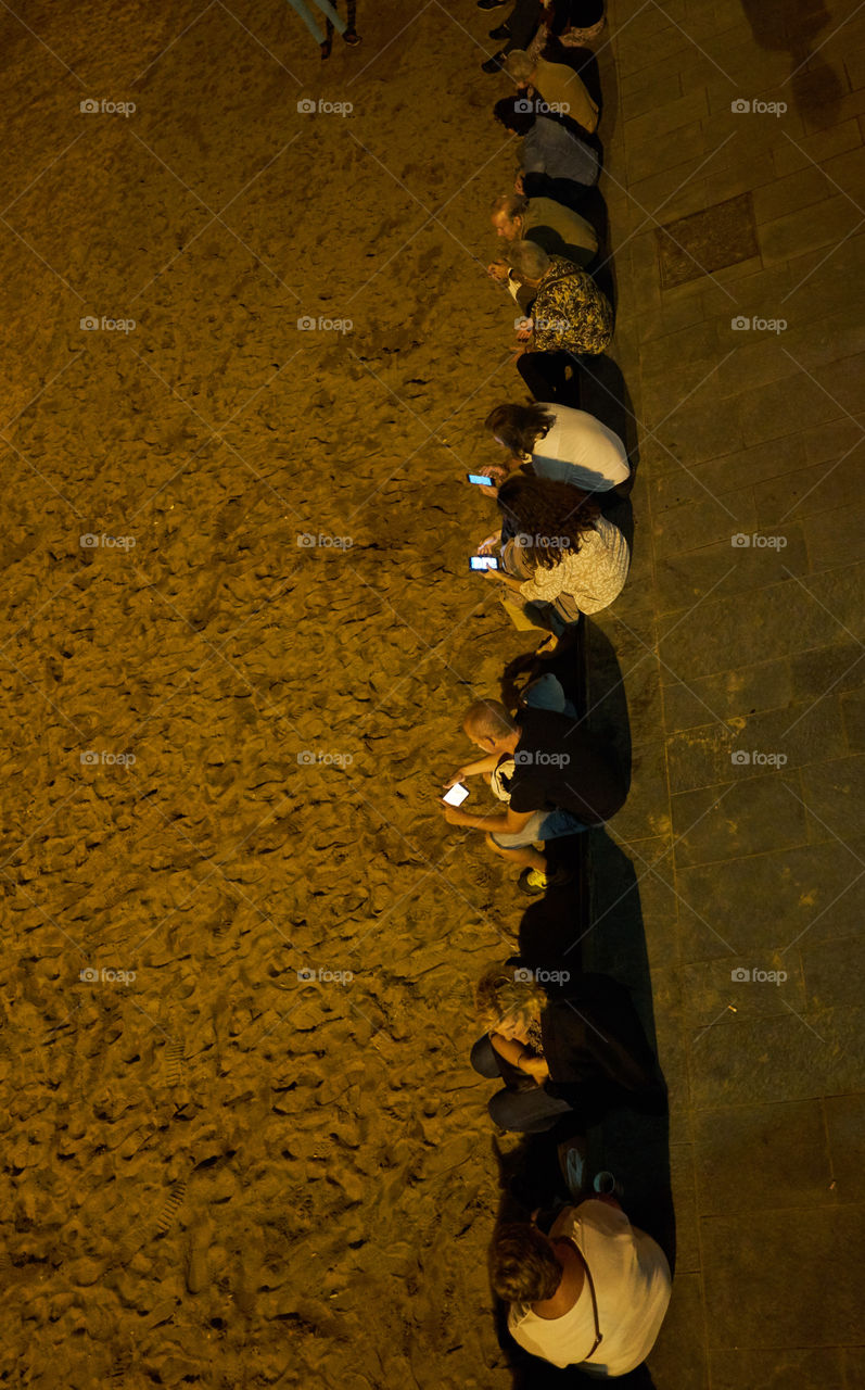 Phone communication in a summer night at the beach