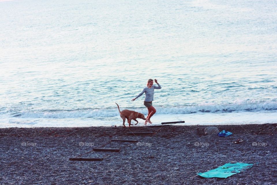 Girl with a dog at the seaside