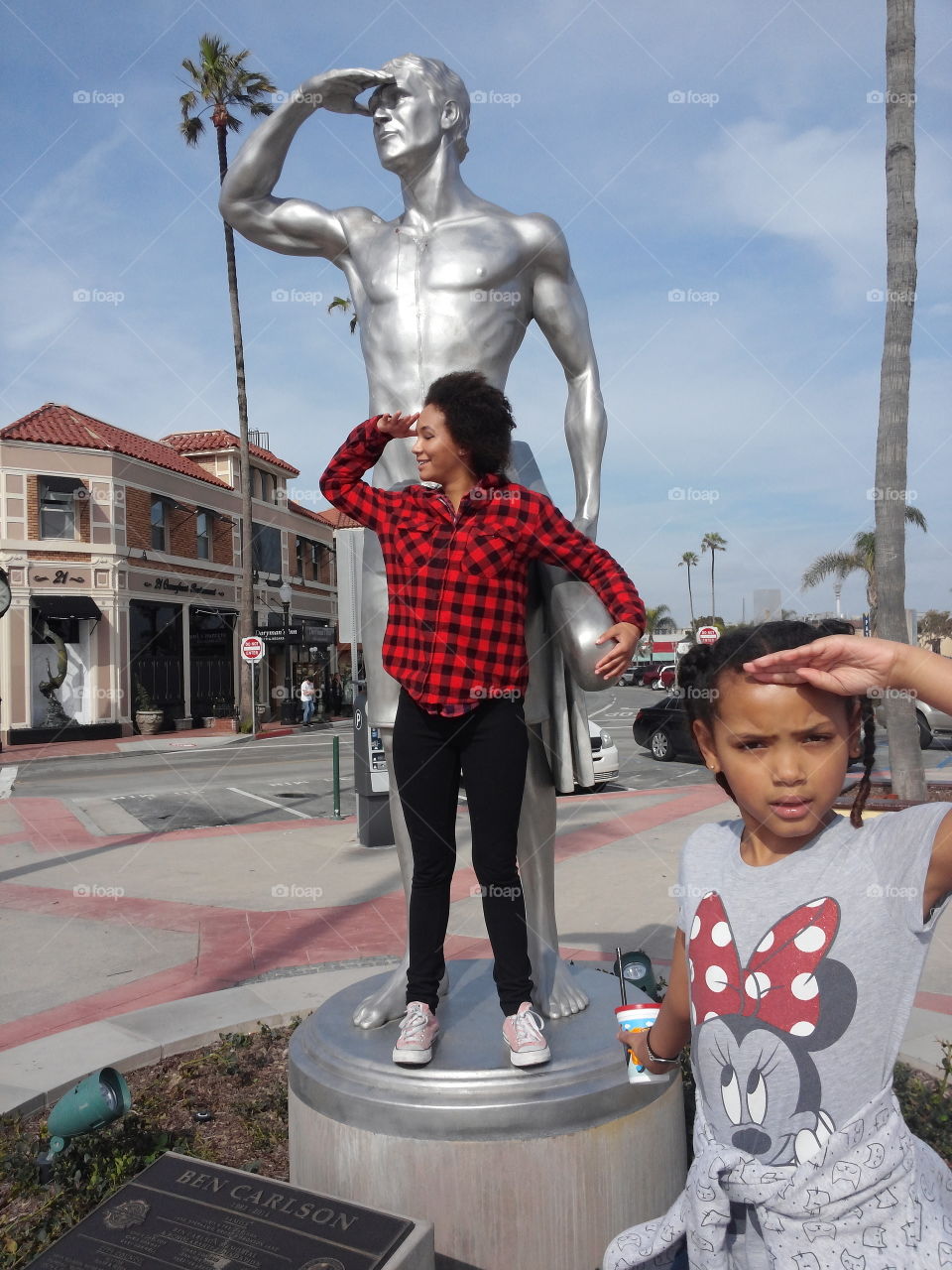 Young woman shielding her eye in front of statue